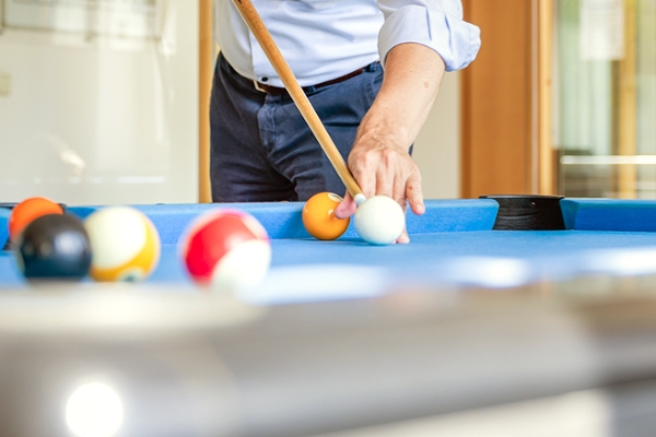 Nahaufnahme von einem Mann beim Billard spielen.