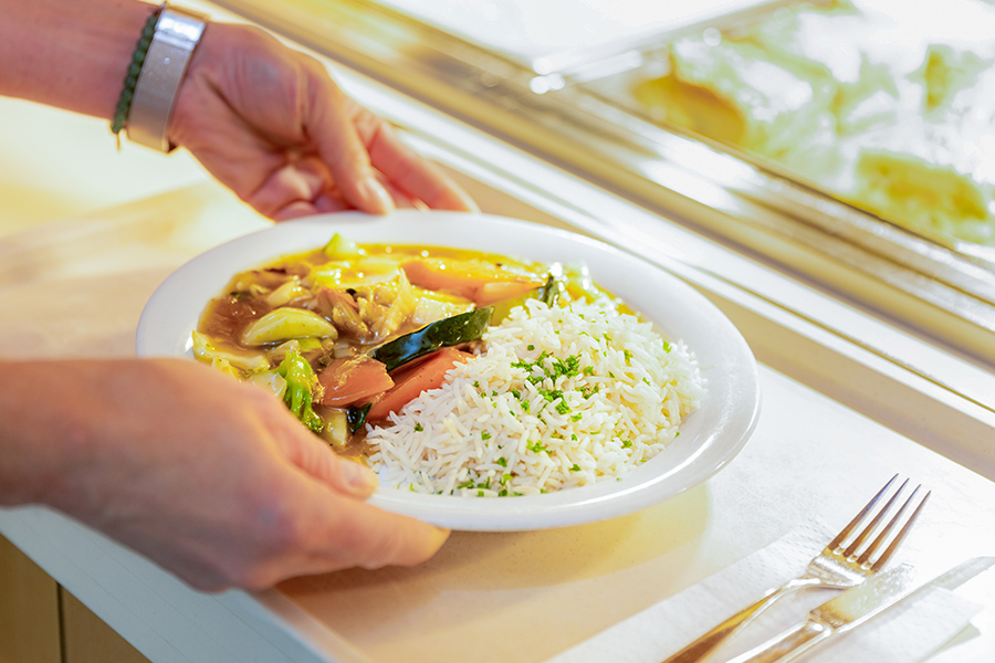 Auf einem Teller ist ein Curry-Gericht mit Reis angerichtet.